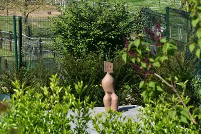 a naked man in a garden with a sign on it at RectoVersoVV in Sint-Pieters-Leeuw