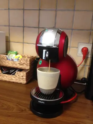a red coffee maker is making a cup of coffee at RectoVersoVV in Sint-Pieters-Leeuw