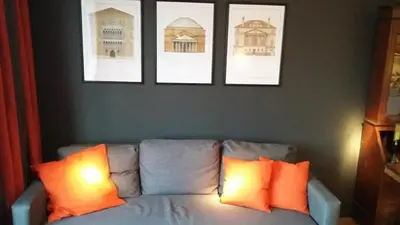 a living room with a couch with two orange pillows at Signature Designers Appartment in Brussels