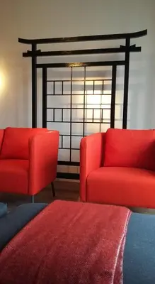 a living room with two red chairs and a window at Signature Designers Appartment in Brussels