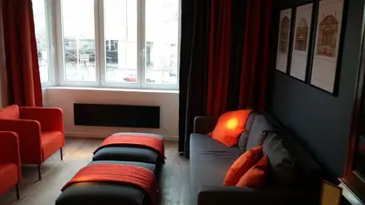 a living room with two couches in front of a window at Signature Designers Appartment in Brussels