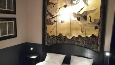 a bedroom with a bed with a painting on the wall at Signature Designers Appartment in Brussels