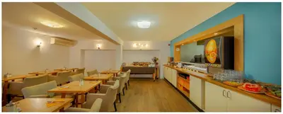 a restaurant with wooden tables and chairs and a counter at Trip Inn Eden Antwerpen in Antwerp