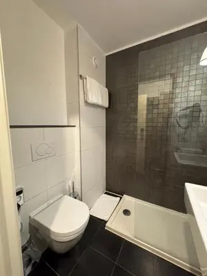 a white bathroom with a toilet and a sink at Trip Inn Eden Antwerpen in Antwerp