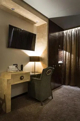 a desk with a lamp and a chair in a room at Thermen Londerzeel Hotel in Londerzeel
