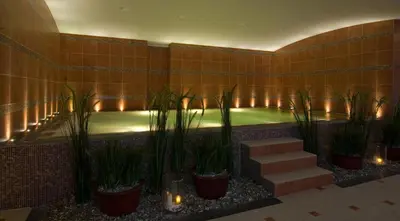 a swimming pool with plants in a building with lights at Thermen Londerzeel Hotel in Londerzeel