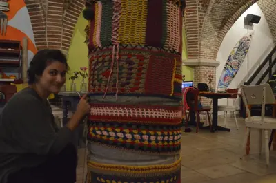 a woman is standing next to a colorful rug at Antwerp City Hostel in Antwerp