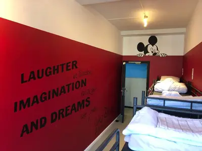 a room with two beds and a red wall at Antwerp City Hostel in Antwerp
