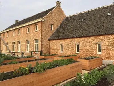 a garden in front of a brick building at De Blauwe Hoeve in Zwijndrecht