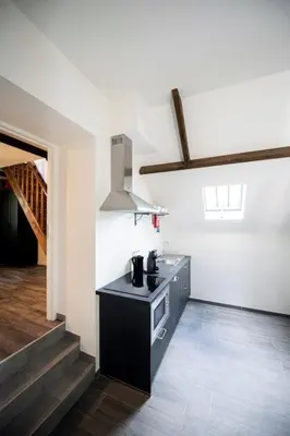 a kitchen with a black island in a room at De Blauwe Hoeve in Zwijndrecht