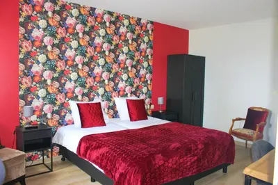 a bedroom with a large bed with a floral wallpaper at De Blauwe Hoeve in Zwijndrecht
