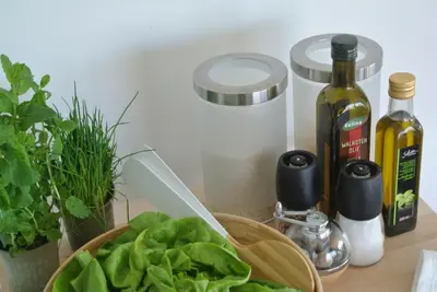 a table with a bowl of lettuce and bottles of wine at Lo-Gies in Lochristi