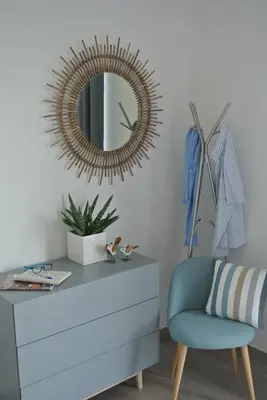 a mirror on the wall above a dresser with a chair at Lo-Gies in Lochristi