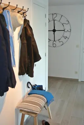 a room with a rack of clothes and a clock at Lo-Gies in Lochristi