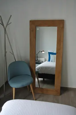 a bedroom with a mirror and a chair and a bed at Lo-Gies in Lochristi