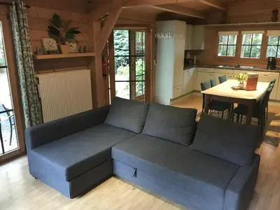 a living room with a couch and a table at Peaceful Chalet Retreat in Nijlen