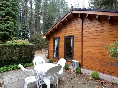 a table and chairs in front of a cabin at Peaceful Chalet Retreat in Nijlen