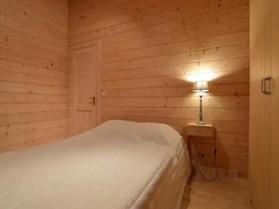 a bedroom with a bed and a lamp on a table at Peaceful Chalet Retreat in Nijlen