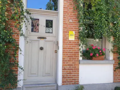 a white door on a brick building with a window at Bed & Breakfast Exterlaer in Antwerp