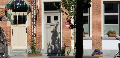 a brick building with a white door and windows at Bed & Breakfast Exterlaer in Antwerp