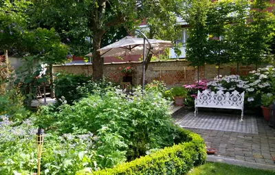 a garden with a white bench and an umbrella at Bed & Breakfast Exterlaer in Antwerp