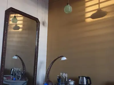 a mirror on a wall next to a table with glasses at Bed & Breakfast Exterlaer in Antwerp