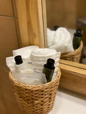 a basket with toiletries and towels in front of a mirror at Hotel The New Fox in Affligem