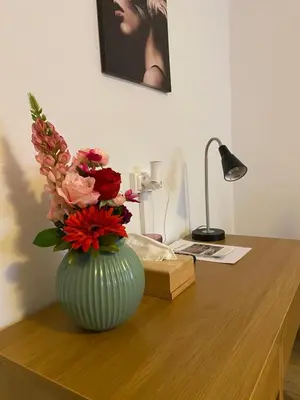 a vase filled with flowers sitting on a desk at Hotel The New Fox in Affligem