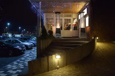 a building with cars parked in a parking lot at night at Hotel The New Fox in Affligem