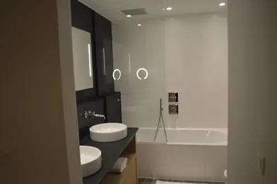a bathroom with two sinks and a bath tub at Hotel The New Fox in Affligem