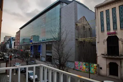 a large building with glass windows on a city street at ATW Apartments in Antwerp