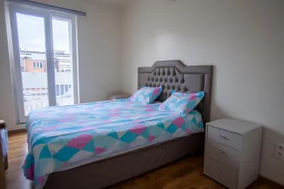 a bedroom with a bed with a colorful comforter and a window at ATW Apartments in Antwerp