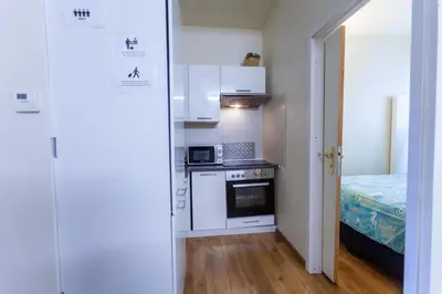 a small kitchen with white cabinets and a bed at ATW Apartments in Antwerp