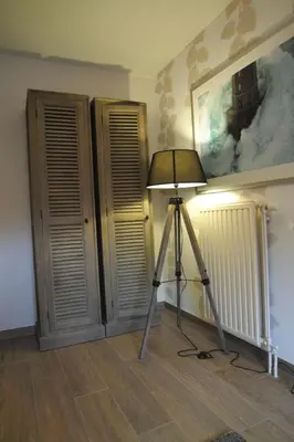 a lamp in a room with a tripod in a room at Bed & Breakfast De Kleine Magnolia in Tessenderlo