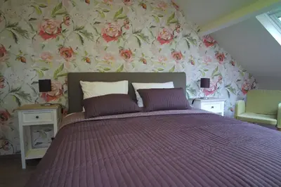 a bedroom with a bed with a floral wallpaper at Bed & Breakfast De Kleine Magnolia in Tessenderlo