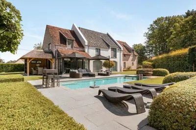 a house with a swimming pool in the yard at B&B Interludium in Nijlen