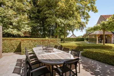 a wooden table and chairs on a patio at B&B Interludium in Nijlen