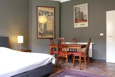 a bedroom with a bed and a table and chairs at Baeten's bed and breakfast in Ghent