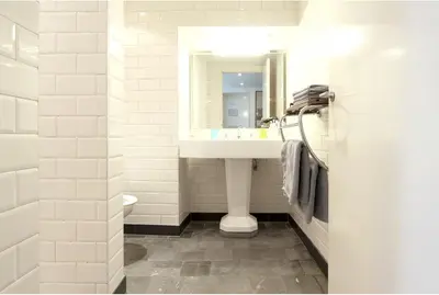 a white bathroom with a sink and a mirror at Baeten's bed and breakfast in Ghent