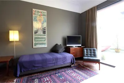 a bedroom with a bed and a tv and a chair at Baeten's bed and breakfast in Ghent