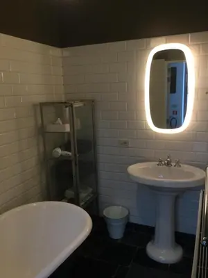 a bathroom with a sink and a tub and a mirror at Baeten's bed and breakfast in Ghent