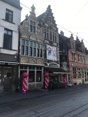 a building with red and white decorations on a street at De Waterzooi Lodge in Ghent