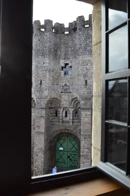 a window view of a castle with a green door at De Waterzooi Lodge in Ghent