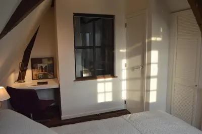 a bedroom with a window and a bed and a desk at De Waterzooi Lodge in Ghent