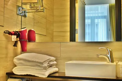 a bathroom with a sink and a mirror and towels at Hotel Agora Brussels Grand Place in Brussels
