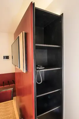 a black bookcase with a television in a room at Hotel Agora Brussels Grand Place in Brussels