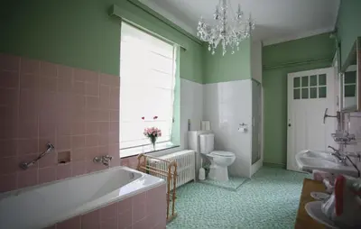 a bathroom with a tub and a toilet and a window at Kasteel Ter Leyen in Boekhoute
