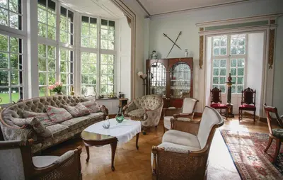 a living room with a couch and chairs and a table at Kasteel Ter Leyen in Boekhoute