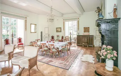 a dining room with a table and chairs at Kasteel Ter Leyen in Boekhoute