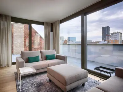 a living room with a couch and a large window at Cadix 35 in Antwerp
